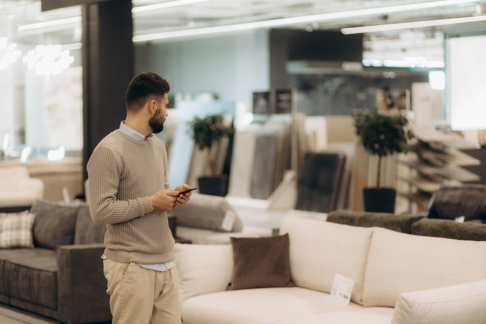 Mann der eine edle weiße Couch betrachtet